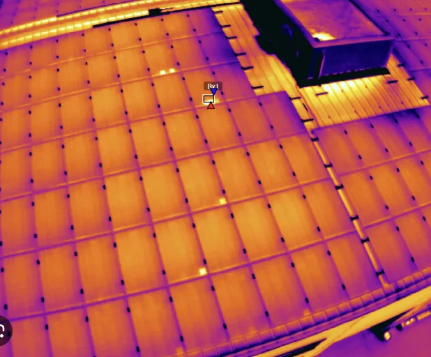 Aerial thermal inspection of rooftop solar panels — hot spots and defective cells visible in IR